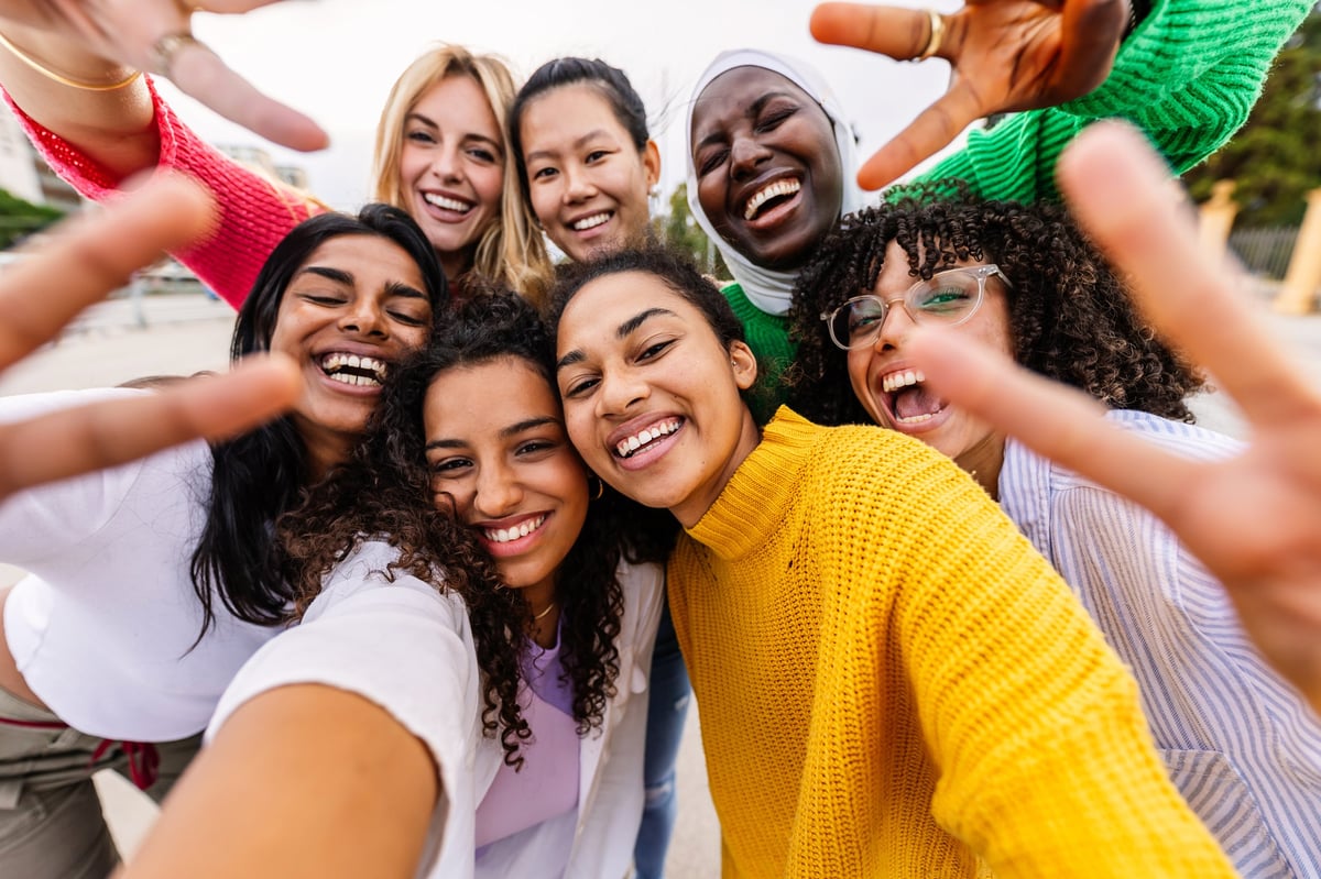 Multiracial group of women smiling together, diverse female community and friendship